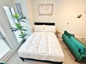 a bedroom with a white bed and a green couch at Tranquil Escape in Des Moines