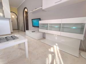 a white kitchen with a stove and a tv at Rincón en el centro de Palamós in Palamós