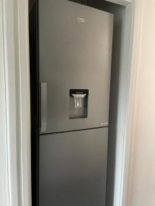 a refrigerator with a water dispenser on top of it at Skylounge Stays in Luton