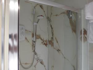 a shower in a bathroom with a marble wall at Juliet Cottage HOT TUB Sleeps 3 Singles or Double in Stratford-upon-Avon +21 photos