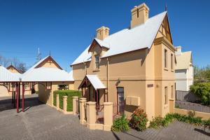 a large yellow building with a white roof at Porters Cottage Grande (two units) in Albury