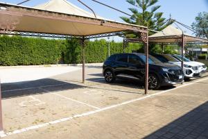 a car parked under a pavilion in a parking lot at Giardini di Marzo Lecce B&B in Lecce
