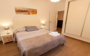 a bedroom with a bed and two lamps and a mirror at Villa 294 by Villamya in El Gastor +30 photos