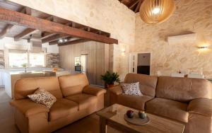 a living room with two brown couches and a kitchen at Villa 294 by Villamya in El Gastor