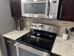 a kitchen with a stove and a microwave at 4BR Luxury, Walk to Old Town, Arcade, Pool, 12 Guests in Scottsdale