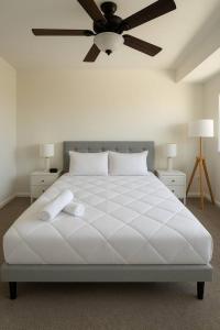 a bedroom with a white bed with a ceiling fan at 4BR Luxury, Walk to Old Town, Arcade, Pool, 12 Guests in Scottsdale +19 photos