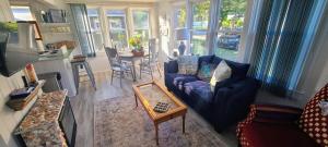 a living room with a blue couch and a table at Crescent Vintage Cottage in Myrtle Beach
