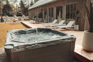 a hot tub on a deck with chairs and a house at Zen House 7 - Villas & Spa in Morin Heights