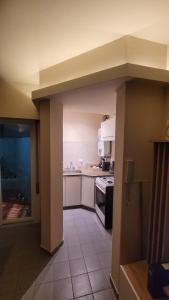 a kitchen with white cabinets and an open doorway at Depto Centro con Patio Pet Friendly La Cañada in Cordoba