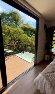 a bedroom with a view of a deck with a tub at Glamping La Cima in San Gil