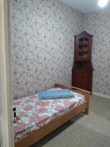 a small bedroom with a bed and a dresser at Lom Bulgarana in Bourg-Argental