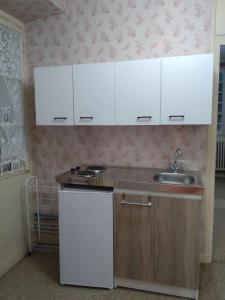a kitchen with white cabinets and a sink at Lom Bulgarana in Bourg-Argental