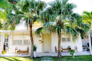 a house with two palm trees in front of it at The Nest in Hollywood