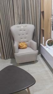 a white chair with a blanket on it in a living room at Willcrown apartments in Lagos +1 photo