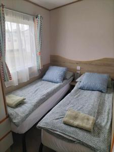 two beds in a small room with a window at Abi static caravan close to Edinburgh in Port Seton +37 photos