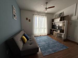a living room with a couch and a television at Canoas Ulbra Parkshopping in Canoas