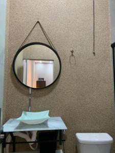 ein Badezimmer mit Spiegel, Waschbecken und Toilette in der Unterkunft Flat MDC 02 in Iturama