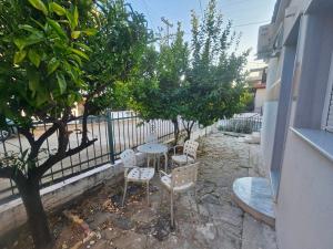 a patio with a table and chairs and trees at Chrysalis House in Nea Potidaea