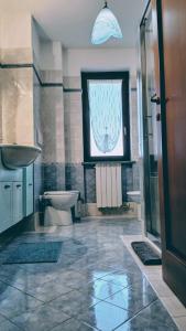 Un baño con lavabo, inodoro y ventana. en la casa di Camilla, en Volvera