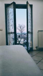 1 dormitorio con ventana y vistas a un árbol en la casa di Camilla, en Volvera