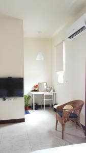 a living room with a television and a desk at 響樂池上電梯民宿1663 Chishang Music Guesthouse in Chishang