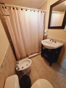 un bagno con un water e un lavandino di El Portal Hoteles y Aparts a Rincon de los Sauces