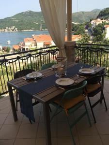 a wooden table with plates and glasses on a balcony at Apartments Fig&Olive in Zaton