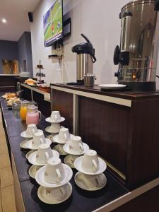 un gruppo di tazze e piattini su un bancone di El Portal Hoteles y Aparts a Rincon de los Sauces