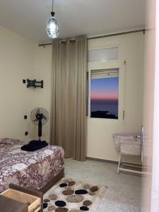 a bedroom with a bed and a window at Sunset Vibes Larache in Larache