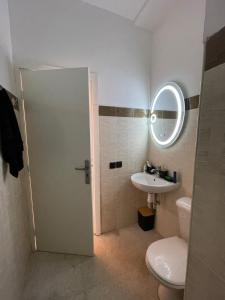 a bathroom with a toilet and a sink and a mirror at Sunset Vibes Larache in Larache +33 photos