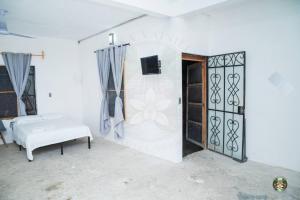 a white room with a bed and a door at Casa Vainilla - Privacy, Best For Families, Tecolutla in Tecolutla