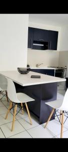 a kitchen with a table and two white chairs at Appartement calme avec balcon in Pouzauges