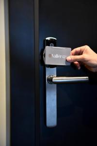 a person holding a cell phone in a door at Vallér Parque Hotel Executive in Lajeado