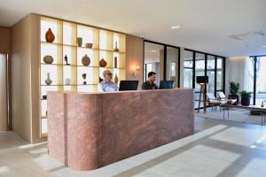 two men sitting at a counter in a lobby at Vallér Parque Hotel Executive in Lajeado