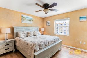 a bedroom with a bed and a ceiling fan at Sea Oats 501 in St Pete Beach