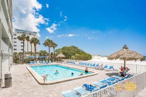 a pool at a resort with chairs and a beach at Sea Oats 501 in St Pete Beach