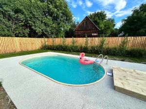 a pool with an inflatable flamingo in a backyard at Cabana Musafir in Bica