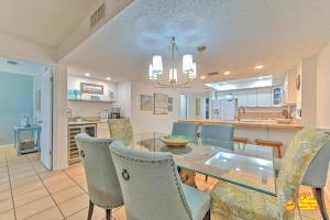 a dining room and kitchen with a glass table and chairs at Sea Oats 407 in St Pete Beach