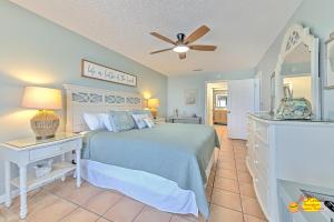 a bedroom with a bed and a ceiling fan at Sea Oats 407 in St Pete Beach