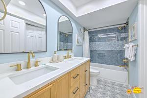 a bathroom with two sinks and a tub and a toilet at Sea Oats 407 in St Pete Beach +23 photos