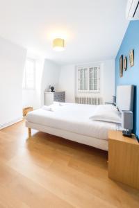 a bedroom with a large white bed and blue walls at La maison aux 5 nids in Saint-Cyr-sur-Loire
