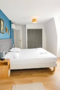 a large white bed in a bedroom with blue walls at La maison aux 5 nids in Saint-Cyr-sur-Loire +21 photos
