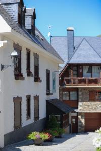 a white building with a porch and a balcony at Hotel Deth Pais in Salardú