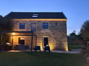 a stone house with a table and chairs in front of it at A casa dos Parladoiros in Mos