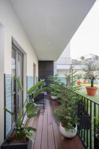 a balcony with plants and chairs on a building at Liiiving in Gaia - Cooper Residence Apartment II in Vila Nova de Gaia