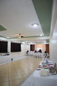 a banquet hall with white tables and white chairs at Hotel Real Monrey in Zihuatanejo
