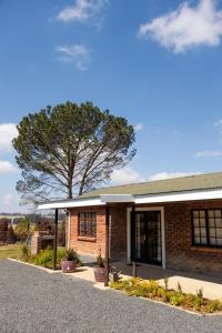 ein Backsteingebäude mit einem Baum im Hintergrund in der Unterkunft Willowdale Farm Cottage 2 in Nottingham Road