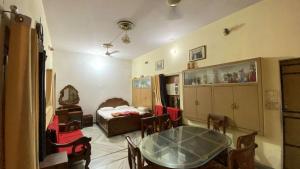 a room with a table and chairs and a bed at Kusum Palace in Varanasi