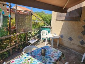 a patio with a table and chairs on a balcony at Charmant 3 pièces terrasse climatisé bord de mer in Lumio