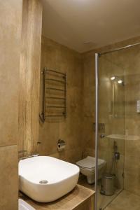 タターリウにあるTatariv-hillsのバスルーム(洗面台、トイレ、ガラス張りのシャワー付)